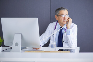 Portrait of senior doctor sitting in medical office