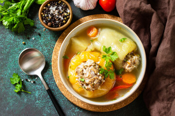 Healthy food. Bell stuffed paprika peppers with meat and bulgur in broth with vegetables. Top view flat lay background.
