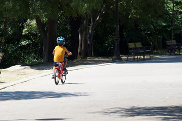 Fototapeta na wymiar one child riding a bike in the summer park