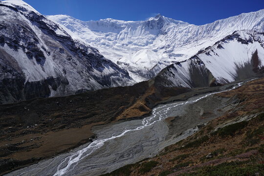 Khangsar Kang and other mountains in Annapurna Mountain range, its glacier, and the river flowing down Tilicho lake in Manang, Nepal.