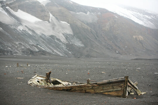 Old wooden boats from an ancient Whaling Station abandoned on the beach of Whalers' Bay in Deception Island, Antarctic Peninsula.
