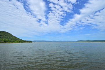 White clouds in blue sky and smooth waves in the water