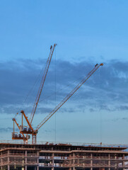 Construction site with cranes symbolize the construction boom in urban areas and urbanization with the population shift from rural to urban areas 