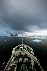 A ship advancing along the misty Lemaire Channel in the Antarctic Peninsula.