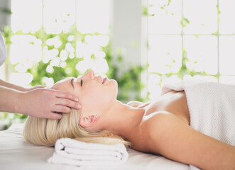 Obraz na płótnie Canvas Beautiful woman doing facial massage in a spa salon