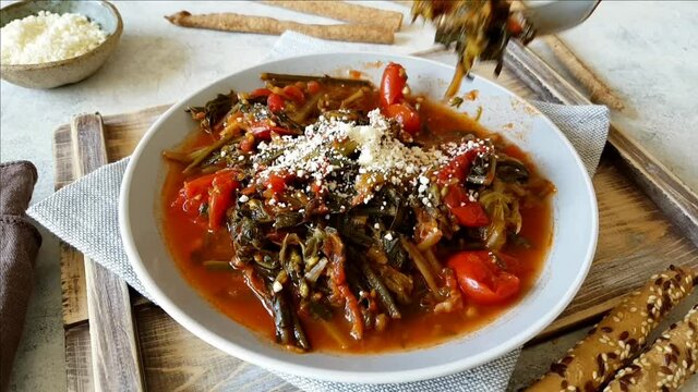 Fork of sauteed green chicory and tomatoes