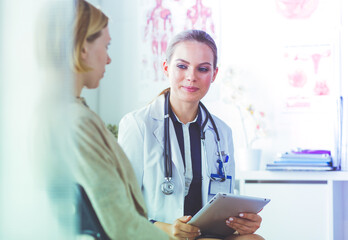 Doctor and patient discussing something while sitting at the table . Medicine and health care...