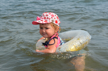 Caucasian child in the sea on the beach in summer