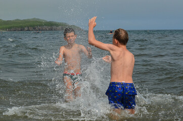 Caucasian children in the sea on the beach in summer