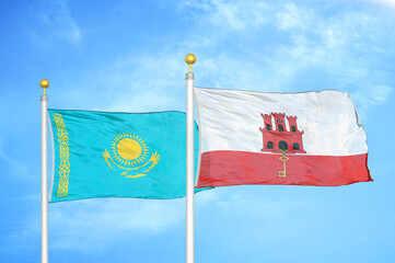 Kazakhstan and Gibraltar two flags on flagpoles and blue sky