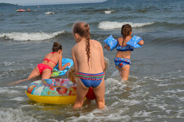 Obraz premium Caucasian children in the sea on the beach in summer