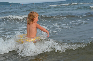 Caucasian child in the sea on the beach in summer