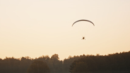 Silhouette of the Paramotor Tandem Gliding And Flying In The Air. Copy space High quality photo