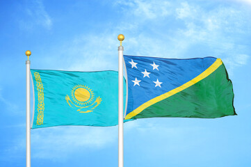 Kazakhstan and Solomon Islands two flags on flagpoles and blue sky