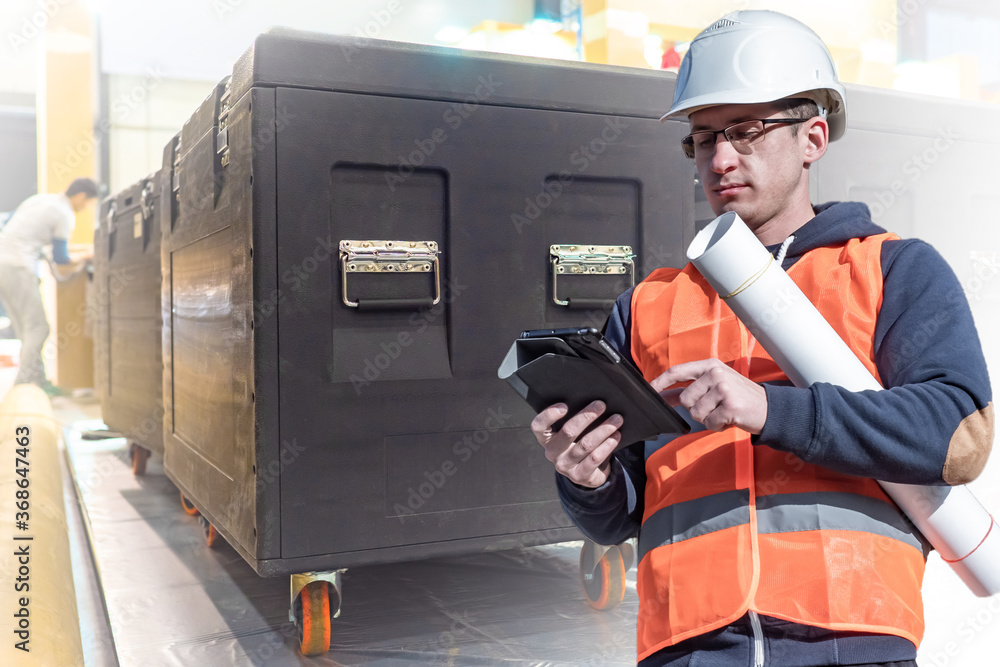 Poster man in a building uniform. musical equipment in black boxes. concept - an engineer thinks how to con