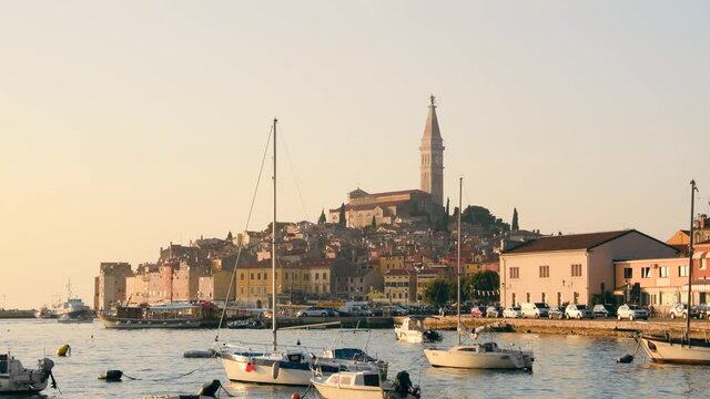 Rovinj marina and city view with boats and St. Euphemia cathedral at sunset. Istria, Croatia.