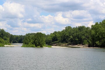 The flowing water of the river in the wooded area of the park.