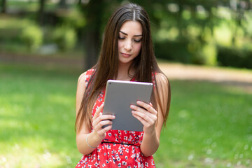 Fototapeta premium Woman using a digital tablet in the park