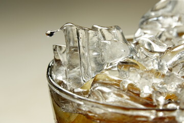 Glass of whiskey with ice cube. Alcohol pouring in the glass from the bottle. Scotch on the rocks....