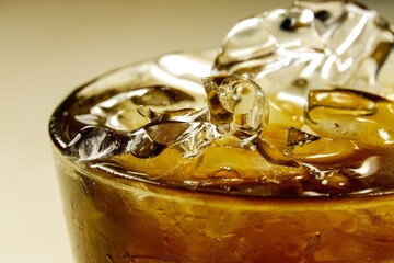 Glass of whiskey with ice cube. Alcohol pouring in the glass from the bottle. Scotch on the rocks....
