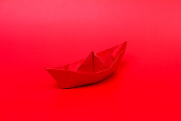 red paper boat on a red background