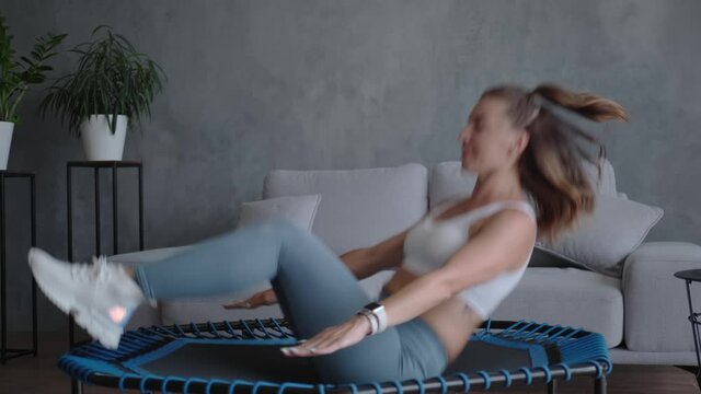 A trainer does abdominal exercises on a mini home trampoline.