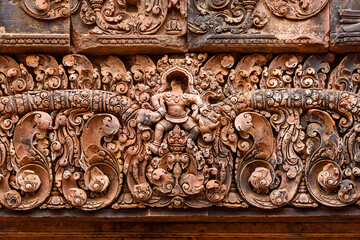 a character with a head cut and stolen at Banteay Srei temple area of Angkor in Siem Reap Cambodia