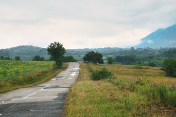 Scenic asphalt countryside road in beautiful mountain valley of Stara Planina on a rainy day