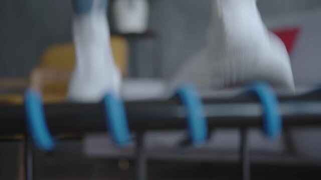 Close-up: female legs in sneakers jumping on a mini trampoline