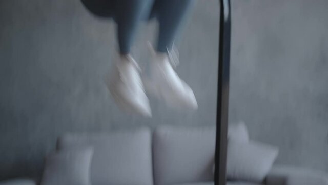 A woman trainer does a home workout on a mini trampoline