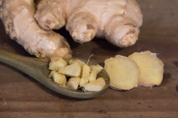 spoon with chopped ginger on rustic wood