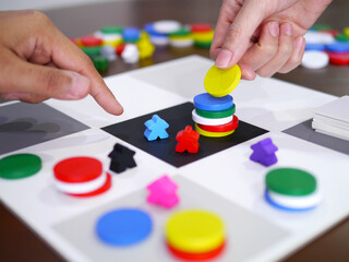 people playing fun board game on wooden table top selected focus
