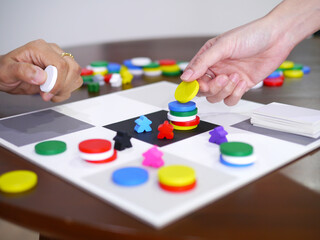 people playing fun board game on wooden table top selected focus