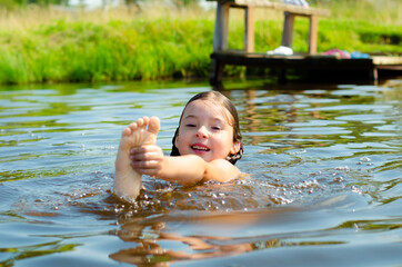 Close up of young beautiful girl in water. Portrait child swimming in the river. Six years caucasian child on vacation. Holiday and summer concept.