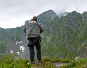 Naklejka premium Hiker man with backpack on a mountain trail