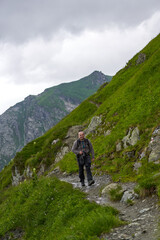 Fototapeta premium Hiker man with backpack on a mountain trail