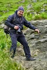 Fototapeta premium Hiker man with backpack on a mountain trail