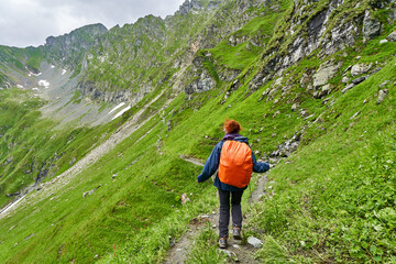 Fototapeta na wymiar Lady hiker on a trail in the mountains