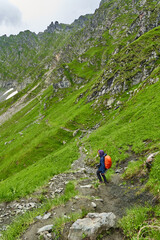 Lady hiker on a trail in the mountains