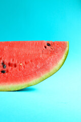 Fresh sliced watermelon isolated on blue background. Ripe red watermelon. Minimal creative concept. Place for text. Bright healthy summer food. Half watermelon