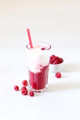 Milk berry refreshing drink, cocktail with ice cream, fresh raspberries in a glass on a white background