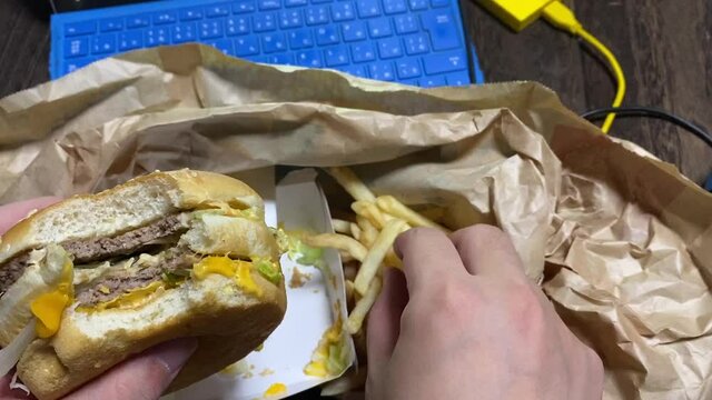 リモートワーク中にハンバーガーとフレンチフライを食べる。ニューノーマル/変わる働き方/日常化する在宅勤務と食生活
