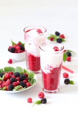 Milk berry refreshing drink, cocktail with ice cream, fresh raspberries and blackberries in a glass on a white background