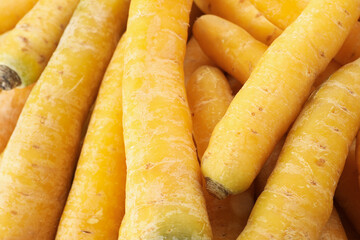 Fresh raw yellow carrots as background, closeup
