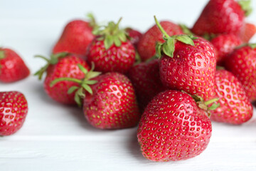 Fototapeta na wymiar Delicious ripe strawberries on white wooden table, closeup