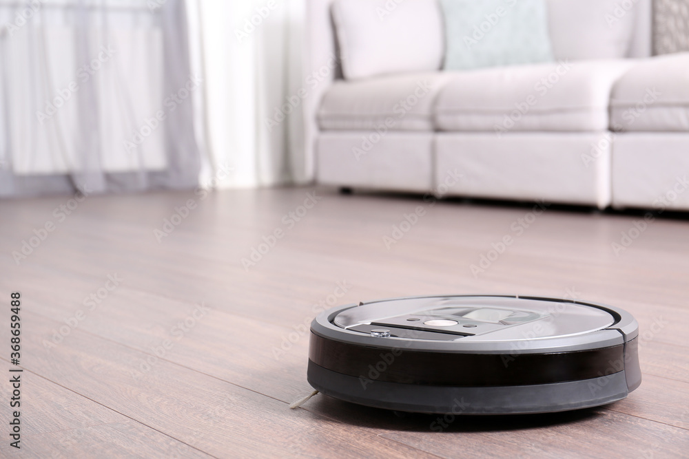 Sticker Hoovering floor with modern robotic vacuum cleaner indoors. Space for text