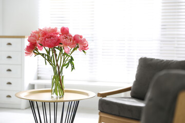 Beautiful bouquet of fragrant peonies in vase on table indoors. Space for text