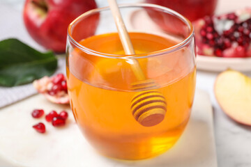 Honey, apples and pomegranate seeds on white marble table, closeup. Rosh Hashanah holiday