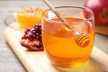 Honey, apples and pomegranate on table, closeup. Rosh Hashanah holiday