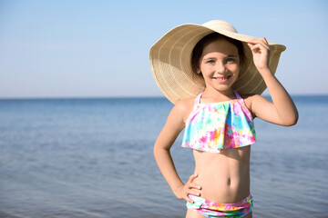 Cute little child with straw hat on sunny day. Beach holiday